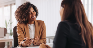 (Smiling professional woman in a business meeting, representing supportive financial or legal consultation for debt relief.)