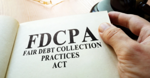 (Close-up of a hand holding a booklet titled "FDCPA – Fair Debt Collection Practices Act," symbolizing consumer protection laws and rights against abusive debt collection.)