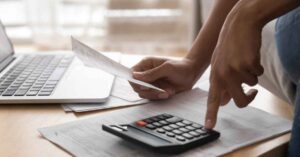 Calculating expenses with a calculator.